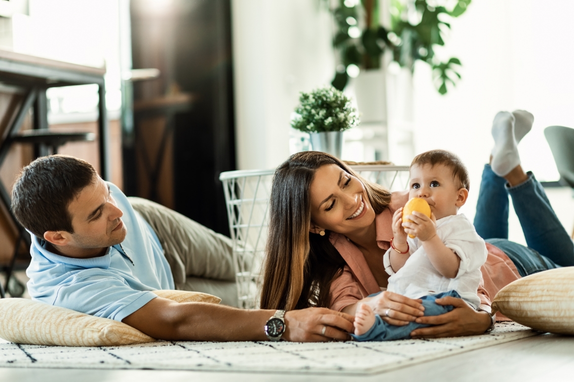 A family lying on the ground with their baby while waiting for HVAC Maintenance in Middletown, OH